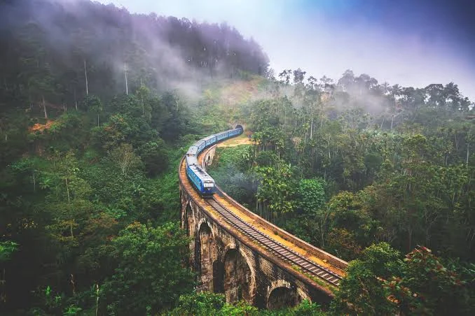Sri Lankan train crossing a misty mountain bridge